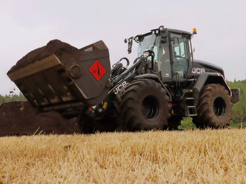 JCB-Radlader mit beladener Hochkipp-Drehmotorschaufel auf dem Feld